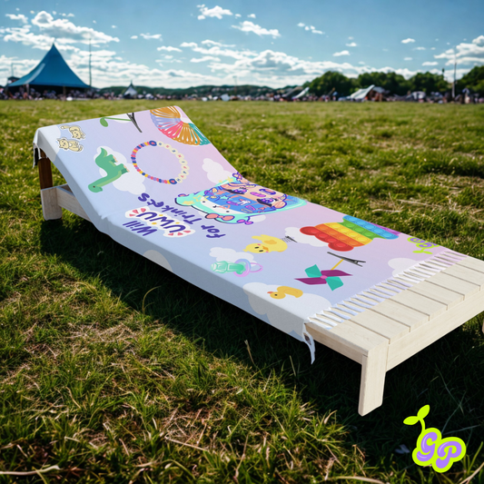 Will UwU for Trinkets kawaii festival pashmina draped over a wooden lawn lounger on the grass with tents in the distance at a music festival.