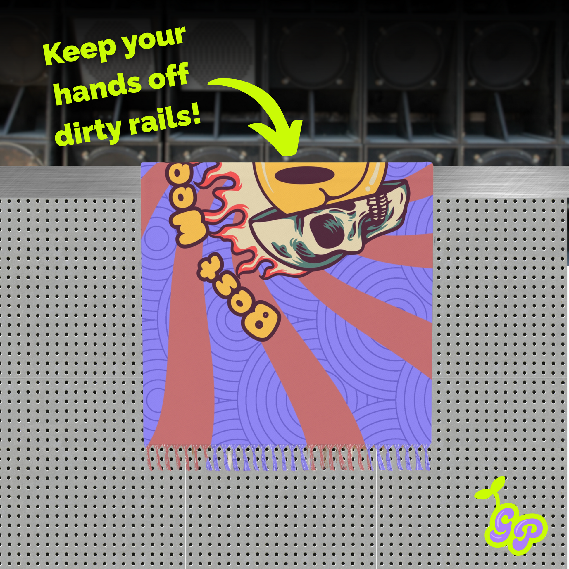 Colorful rave pashmina used as a barrier on dirty rails with bold skull print, neon text, and speakers in the background.